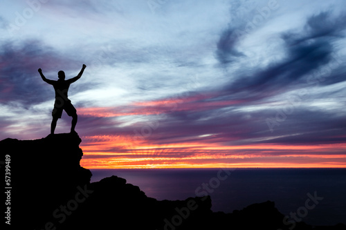 Photo: Man hiking silhouette in mountains, ocean and sunset Man hiking silhouette in mountains, ocean and sunset