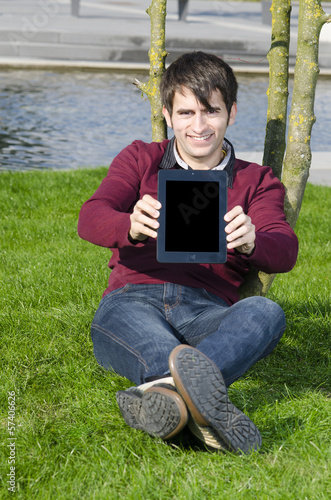 Photo: junger mann zeigt tabletpc junger mann zeigt tabletpc