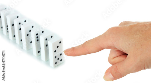 Photo: Hand pushing dominoes isolated on white Hand pushing dominoes isolated on white
