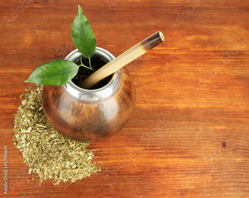 Photo: Calabash and bombilla with yerba mate on wooden background Calabash and bombilla with yerba mate on wooden background
