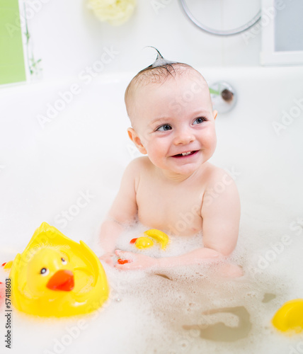Photo: smiling baby girl taking bath and playing with toys smiling baby girl taking bath and playing with toys