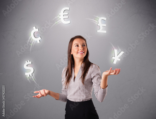 Photo: young lady standing and juggling with currency icons young lady standing and juggling with currency icons