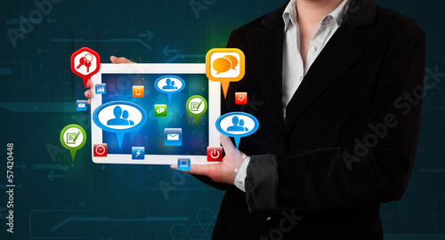 Photo: Girl presenting a tablet with colorful social icons and signs Girl presenting a tablet with colorful social icons and signs