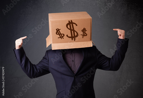 Photo: Young man gesturing with a cardboard box on his head with dollar Young man gesturing with a cardboard box on his head with dollar