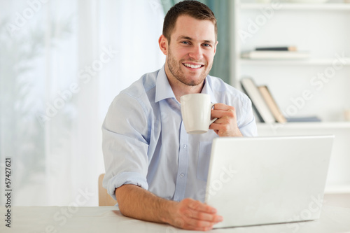 Photo: Smiling businessman having a cup of tea Smiling businessman having a cup of tea