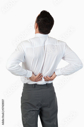 Photo: Portrait of the painful back of a young businessman Portrait of the painful back of a young businessman