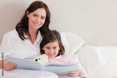 Photo: Happy mother reading a story to her daughter Happy mother reading a story to her daughter