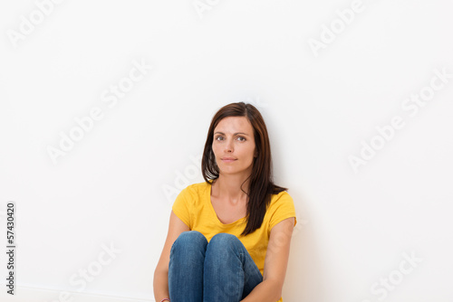 Photo: schöne frau sitzt vor weißer wand schöne frau sitzt vor weißer wand