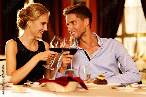 Photo: Beautiful young couple with glasses of red wine Beautiful young couple with glasses of red wine