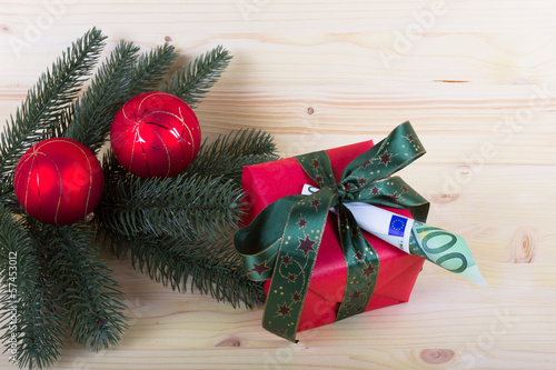 Photo: Weihnachtsgeschenk mit Geldschein und Tannenzweig Weihnachtsgeschenk mit Geldschein und Tannenzweig