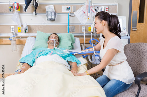 Photo: Woman Looking At Man Lying On Bed Woman Looking At Man Lying On Bed
