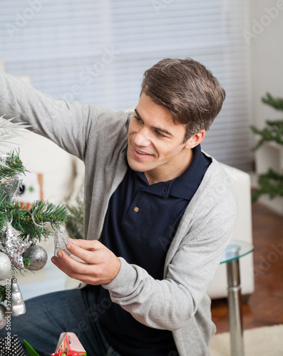 Photo: Man Decorating Christmas Tree Man Decorating Christmas Tree