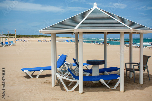Photo: sunny calm beach with deckchairs sunny calm beach with deckchairs