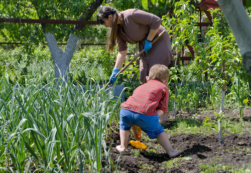 Photo: Mother and son working in the vegetable garden Mother and son working in the vegetable garden