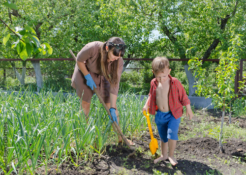 Photo: Little boy helping his mother in the garden Little boy helping his mother in the garden