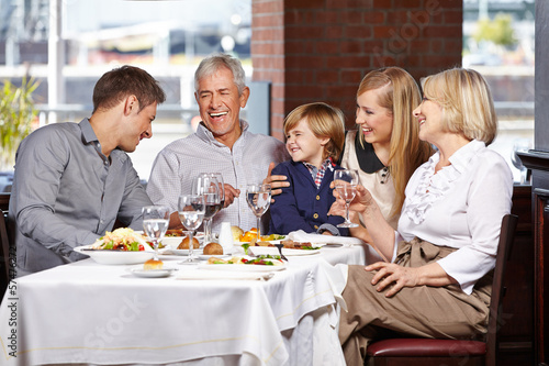 Photo: Happy family smiling together in restaurant Happy family smiling together in restaurant