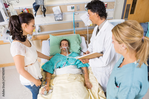 Photo: Doctor And Nurse With Woman Looking At Critical Patient Doctor And Nurse With Woman Looking At Critical Patient