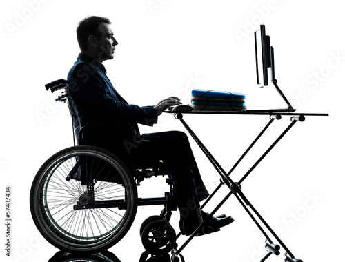 Photo: handicapped business man computing laptop computer in wheelchai handicapped business man computing laptop computer in wheelchai