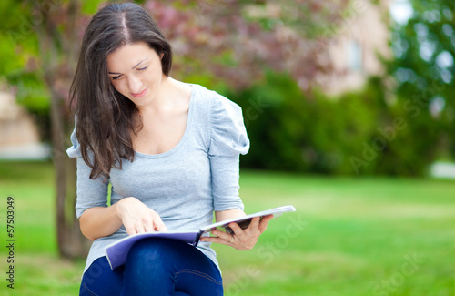 Photo: Young student reading in the park Young student reading in the park