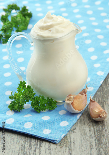 Photo: Sour cream in pitcher on table close-up Sour cream in pitcher on table close-up