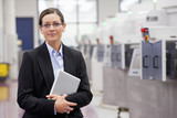 Photo: Portrait of smiling businesswoman holding digital tablet in hi-tech manufacturing plant Portrait of smiling businesswoman holding digital tablet in hi-tech manufacturing plant
