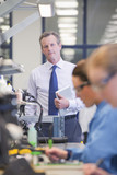 Foto: Portrait of businessman with digital tablet at production line in circuit board manufacturing plant Portrait of businessman with digital tablet at production line in circuit board manufacturing plant