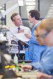 Foto: Businessman and engineer talking at production line in circuit board manufacturing plant Businessman and engineer talking at production line in circuit board manufacturing plant