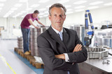 Photo: Portrait of serious manager with arms crossed in steel bearing manufacturing plant Portrait of serious manager with arms crossed in steel bearing manufacturing plant