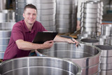 Photo: Portrait of smiling technician checking steel roller bearing inventory in warehouse Portrait of smiling technician checking steel roller bearing inventory in warehouse