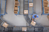 Foto: Worker with bar code reader scanning box on conveyor belt in distribution warehouse Worker with bar code reader scanning box on conveyor belt in distribution warehouse