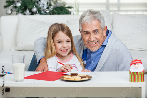 Photo: Happy Grandfather And Girl With Cardpaper Happy Grandfather And Girl With Cardpaper