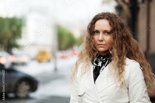 Photo: Beautiful woman in white on the city street Beautiful woman in white on the city street