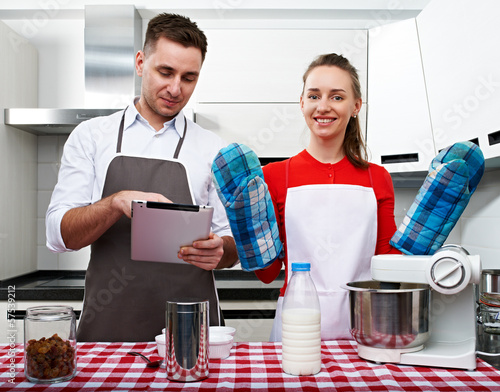 Photo: Couple at kitchen with tablet pc Couple at kitchen with tablet pc