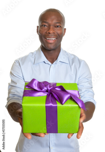 Photo: Laughing african man showing a gift for christmas Laughing african man showing a gift for christmas