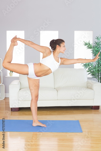 Photo: Concentrated slim woman stretching her body in yoga pose Concentrated slim woman stretching her body in yoga pose