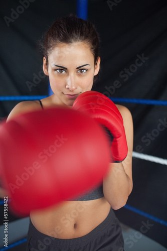 Photo: Beautiful woman in red boxing gloves in the ring Beautiful woman in red boxing gloves in the ring