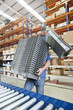 Photo: Portrait of smiling worker scanning boxes on production line in distribution warehouse Portrait of smiling worker scanning boxes on production line in distribution warehouse