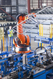 Photo: Worker controlling robotic machinery lifting steel fencing on production line in manufacturing plant Worker controlling robotic machinery lifting steel fencing on production line in manufacturing plant
