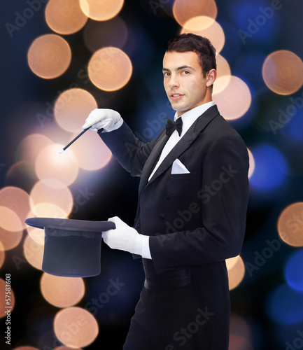 Photo: magician in top hat with magic wand showing trick magician in top hat with magic wand showing trick