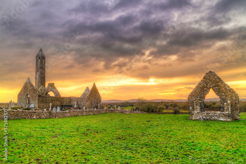 Photo: Kilmacduagh monastery with stone tower at sunset, Ireland Kilmacduagh monastery with stone tower at sunset, Ireland