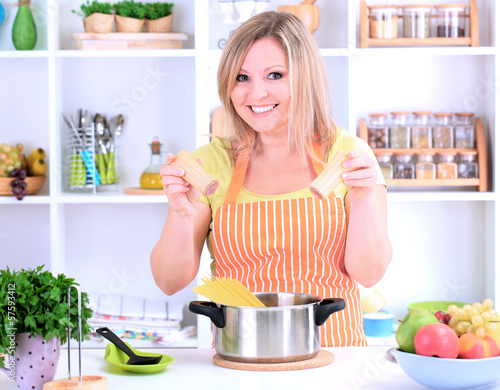 Photo: Happy smiling woman in kitchen preparing for healthy meal Happy smiling woman in kitchen preparing for healthy meal