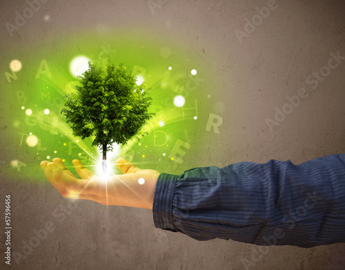 Photo: Glowing tree growing in the hand of a woman Glowing tree growing in the hand of a woman