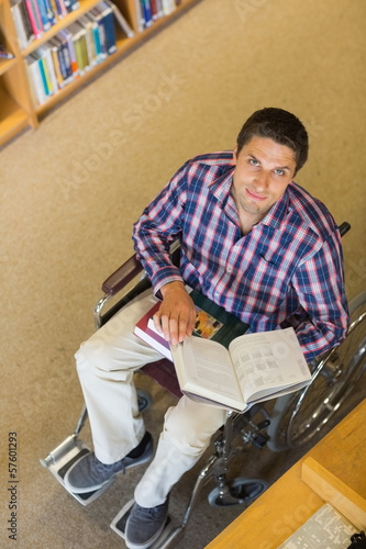 Photo: Portrait of a man in wheelchair reading a book in library Portrait of a man in wheelchair reading a book in library