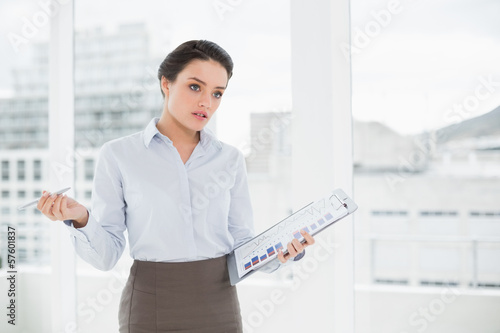 Photo: Elegant businesswoman with graphs in office Elegant businesswoman with graphs in office