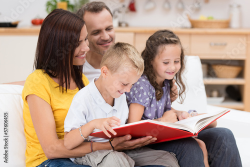 Photo: familie liest gemeinsam in einem buch familie liest gemeinsam in einem buch