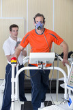 Photo: Sports scientist with digital tablet monitoring runner with mask on treadmill in laboratory Sports scientist with digital tablet monitoring runner with mask on treadmill in laboratory