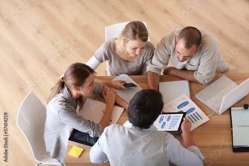 Photo: Upper view of business people around table Upper view of business people around table
