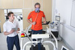 Photo: Sports scientist with digital tablet monitoring runner with mask on treadmill in laboratory Sports scientist with digital tablet monitoring runner with mask on treadmill in laboratory