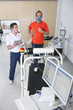 Photo: Sports scientist with digital tablet monitoring runner with mask on treadmill in laboratory Sports scientist with digital tablet monitoring runner with mask on treadmill in laboratory