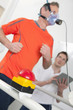 Photo: Sports scientist with digital tablet monitoring runner with mask on treadmill in laboratory Sports scientist with digital tablet monitoring runner with mask on treadmill in laboratory